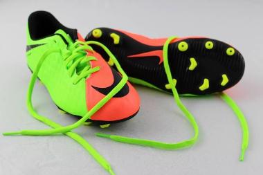 Neon green and orange Nike trainers with black soles and bright yellow studs