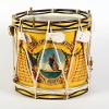Side-view of a yellow snare drum. The drum is decorated with the Royal Norfolk Regiment's insignia - a painting of Britannia. Text on the drum reads 